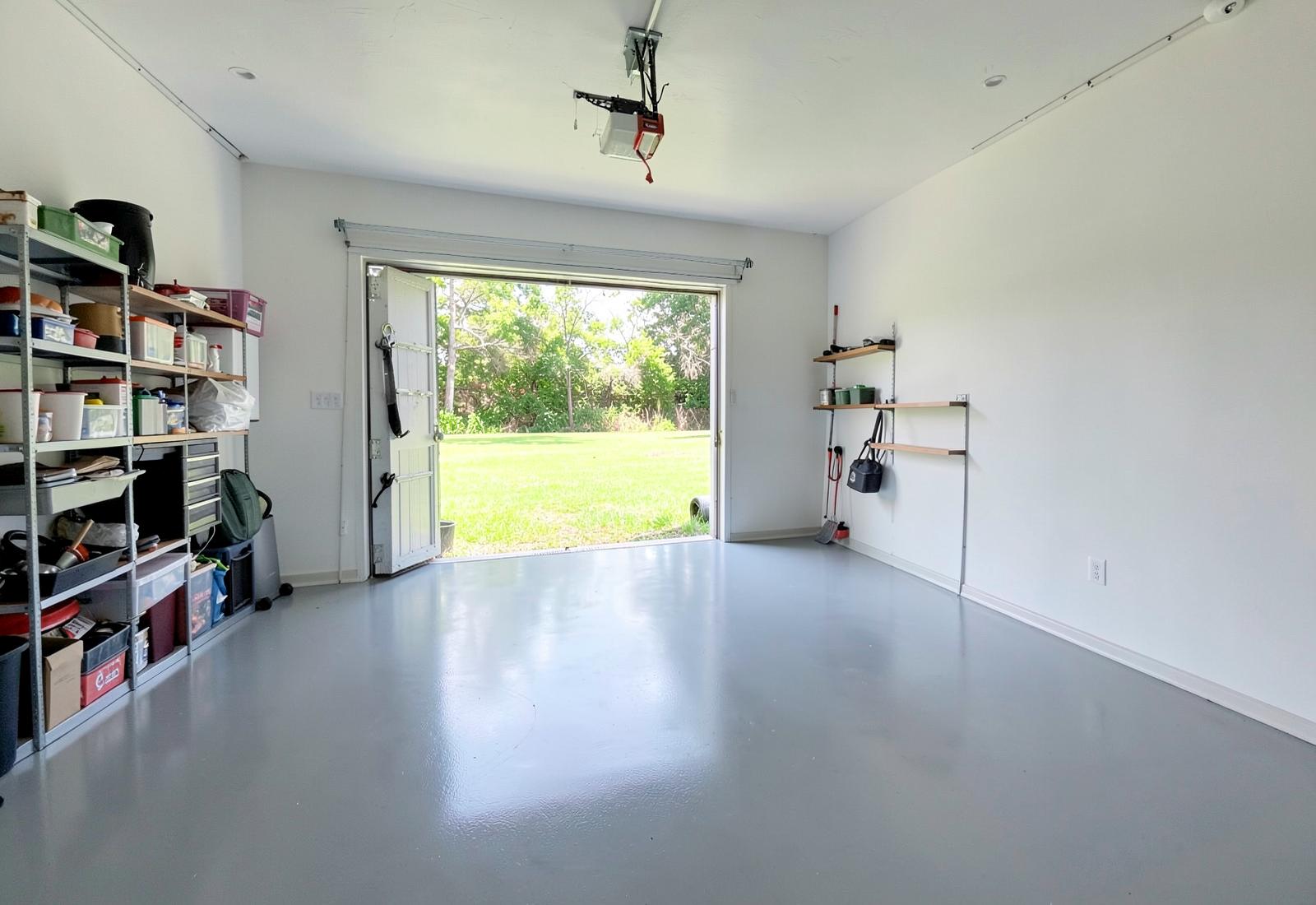 Spacious garage interior with coated floor and storage shelving